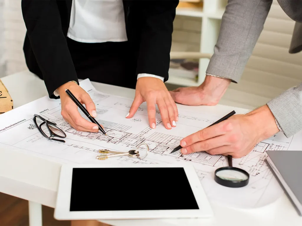 Property administrators analyzing architectural blueprints and keys for residential building maintenance and compliance.